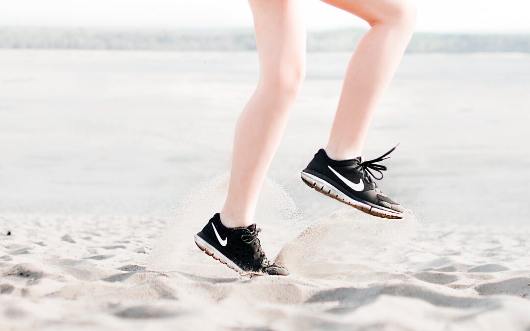 Woman running on sand in trainers