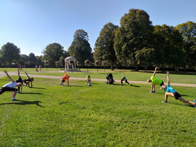 Runners doing yoga in a field